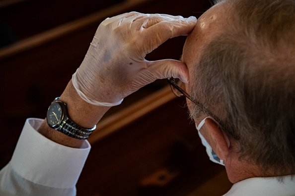 Un vieil homme portant un masque et des gants. | Photo : Getty Images