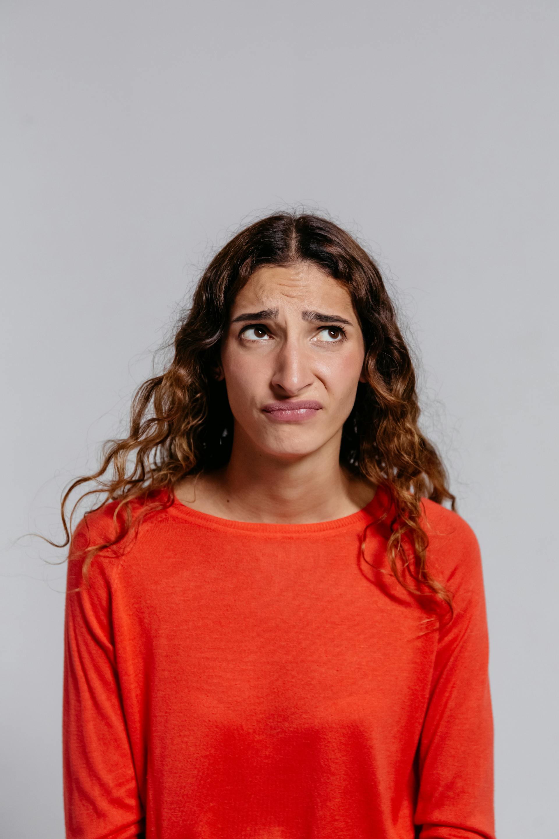 A young woman furrowing her brows and looking up | Source: Pexels