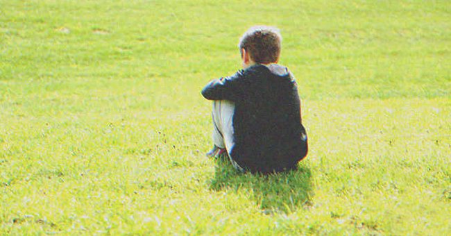 Un niño sentado en la grama de un parque. | Foto: Shutterstock