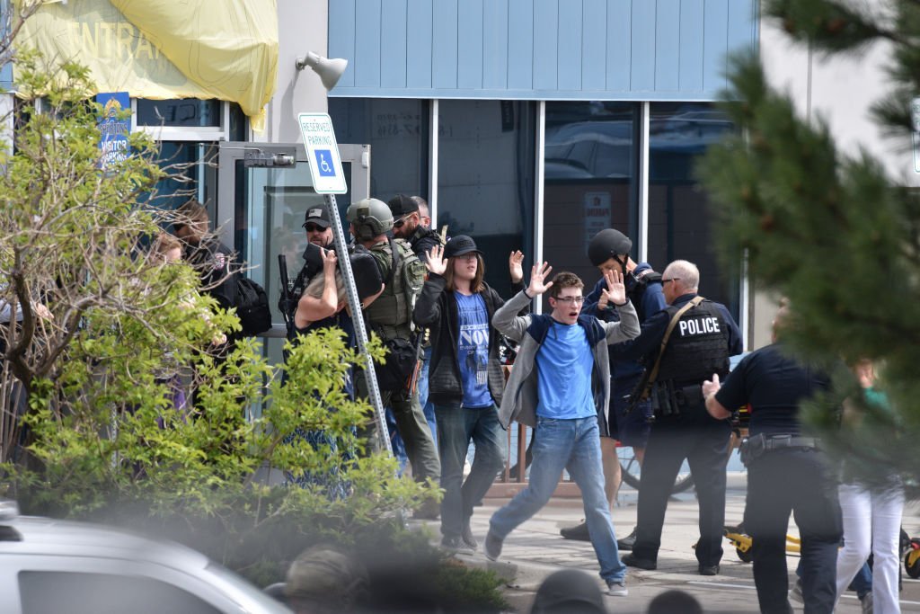 Students and teachers raise their arms as the exit the scene of a shooting at the STEM School Highlands Ranch on May 7, 2019. Photo: Getty Images