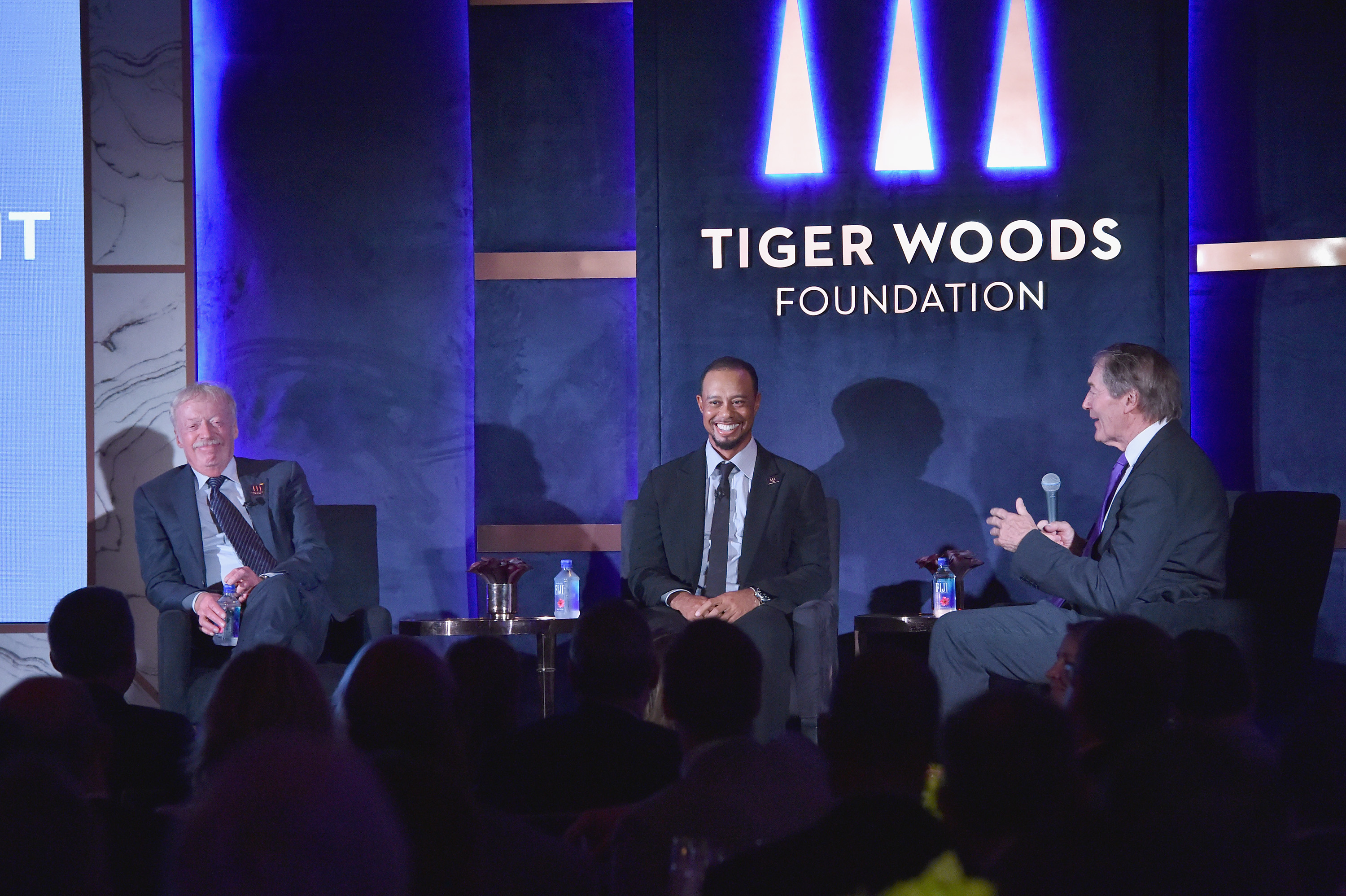 Phil Knight, Tiger Woods, and Charlie Rose speak onstage at the Tiger Woods Foundation’s 20th anniversary celebration in New York City on October 20, 2016. | Source: Getty Images