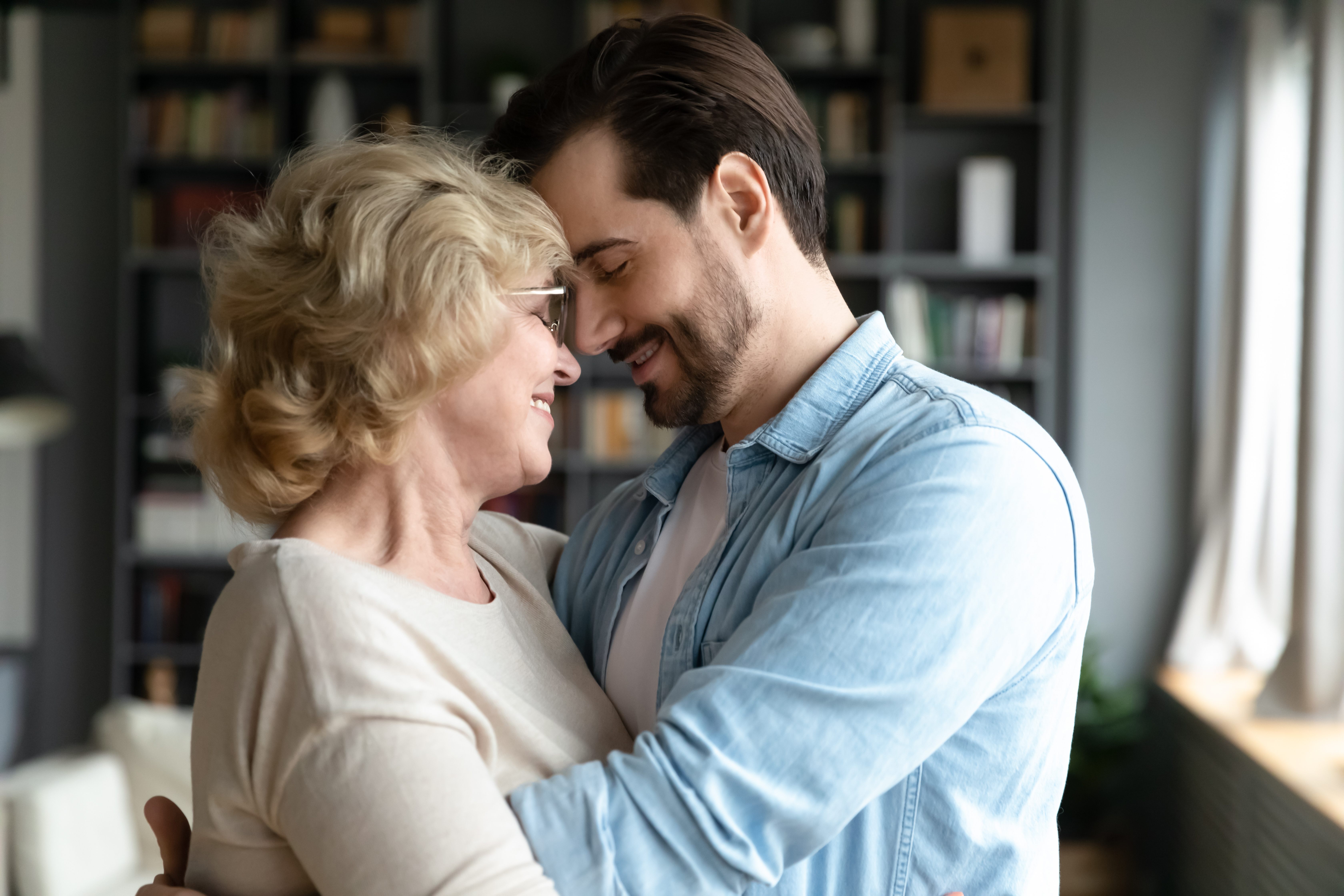 A young man happily embracing an older woman | Source: Shutterstock