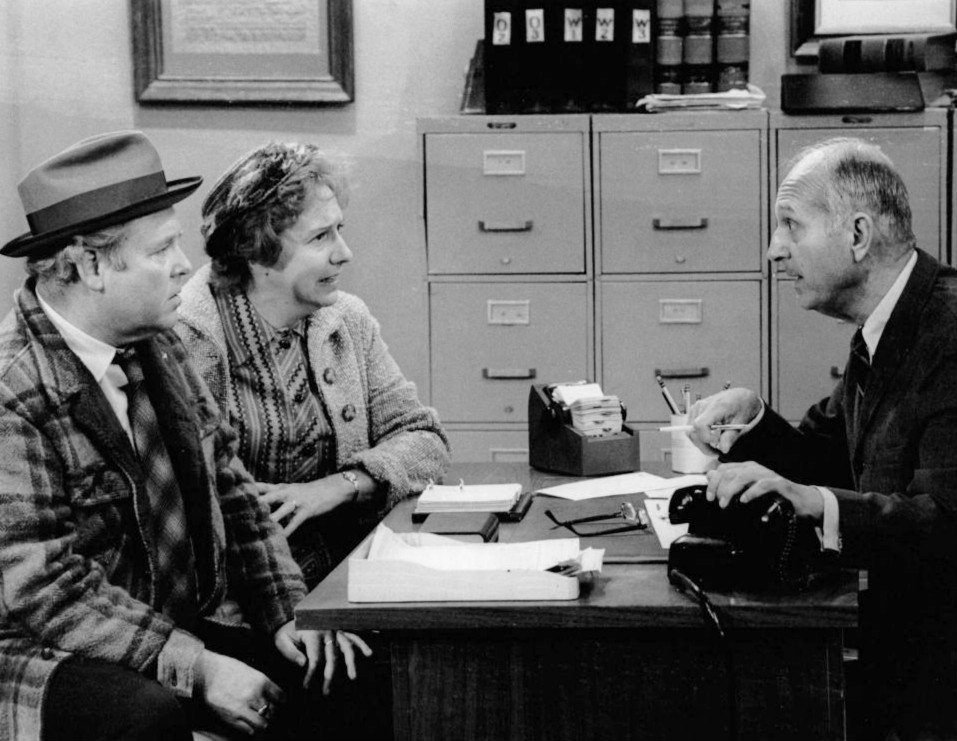 Publicity photo of Carroll O'Connor and Jean Stapleton as Archie and Edith Bunker and guest star James O'Reare as the government official in 1973. | Source: Wikimedia Commons.