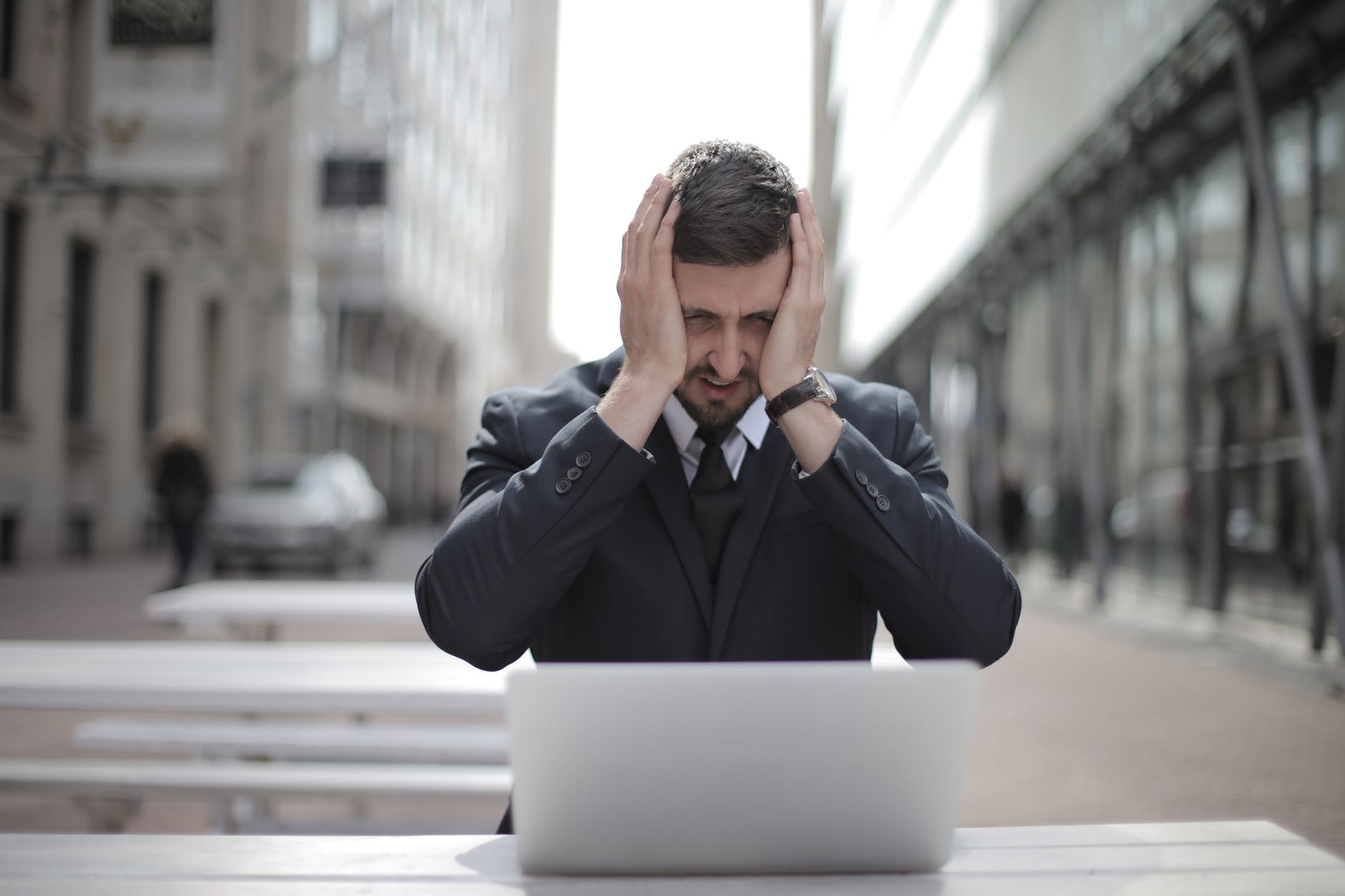 Stressed man in a suit in front of his laptop | Source: Pexels