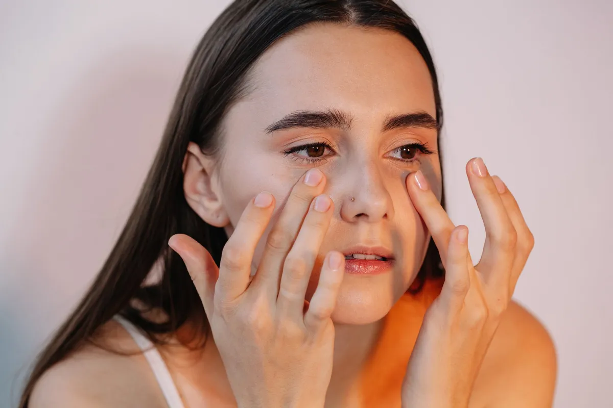 Une femme applique une lotion sur son visage. | Photo : Getty Images