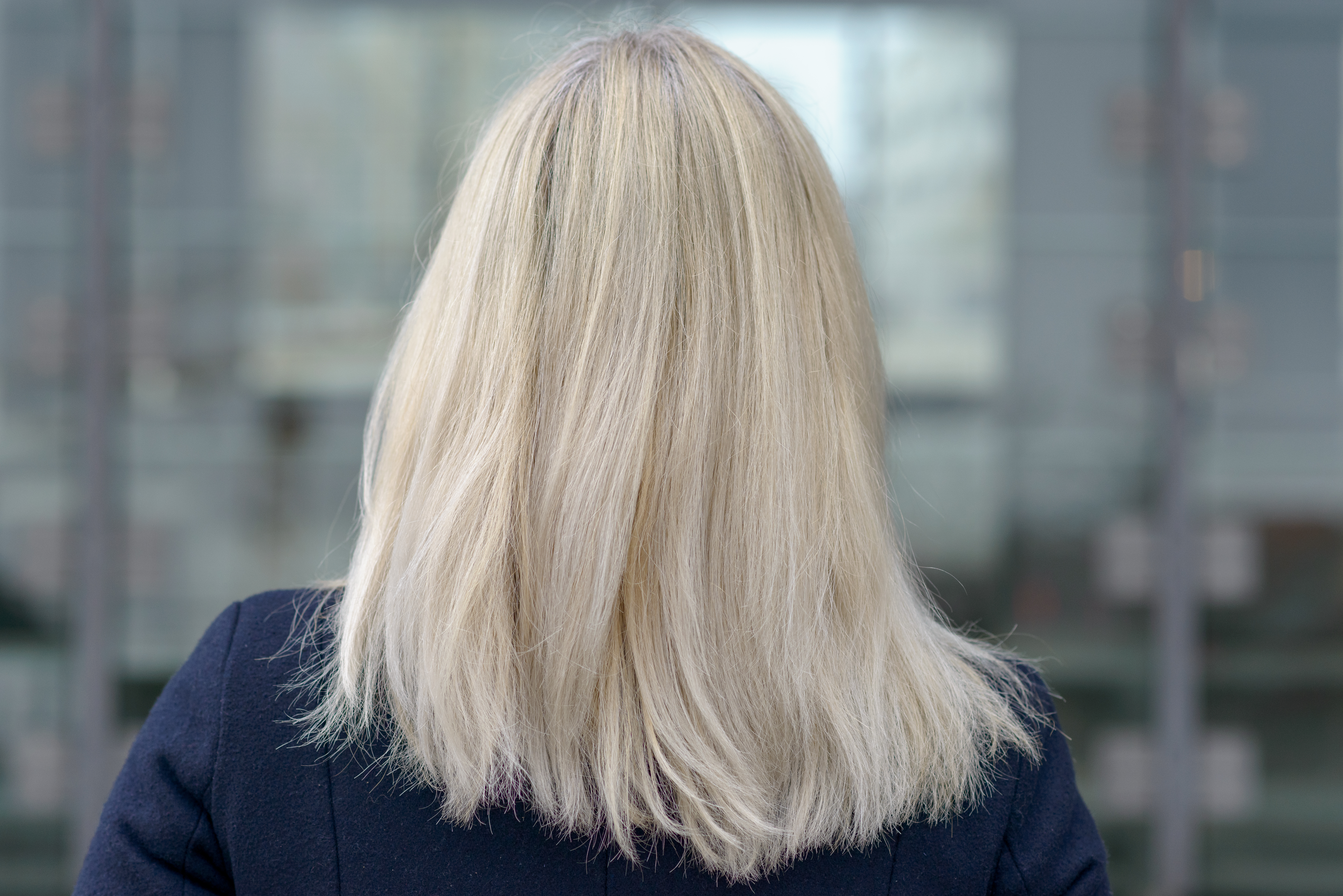 A rear view of a woman with shoulder-length blonde hair | Source: Shutterstock