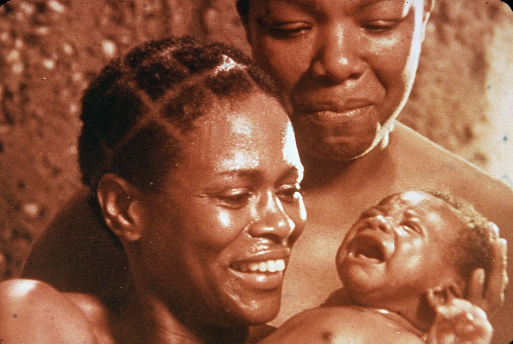 Cicely Tyson and Maya Angelou in a scene for "Roots" as they stare lovingly at a baby on January 01, 1977 | Photo: Fotos International/Hulton Archive/Getty Images
