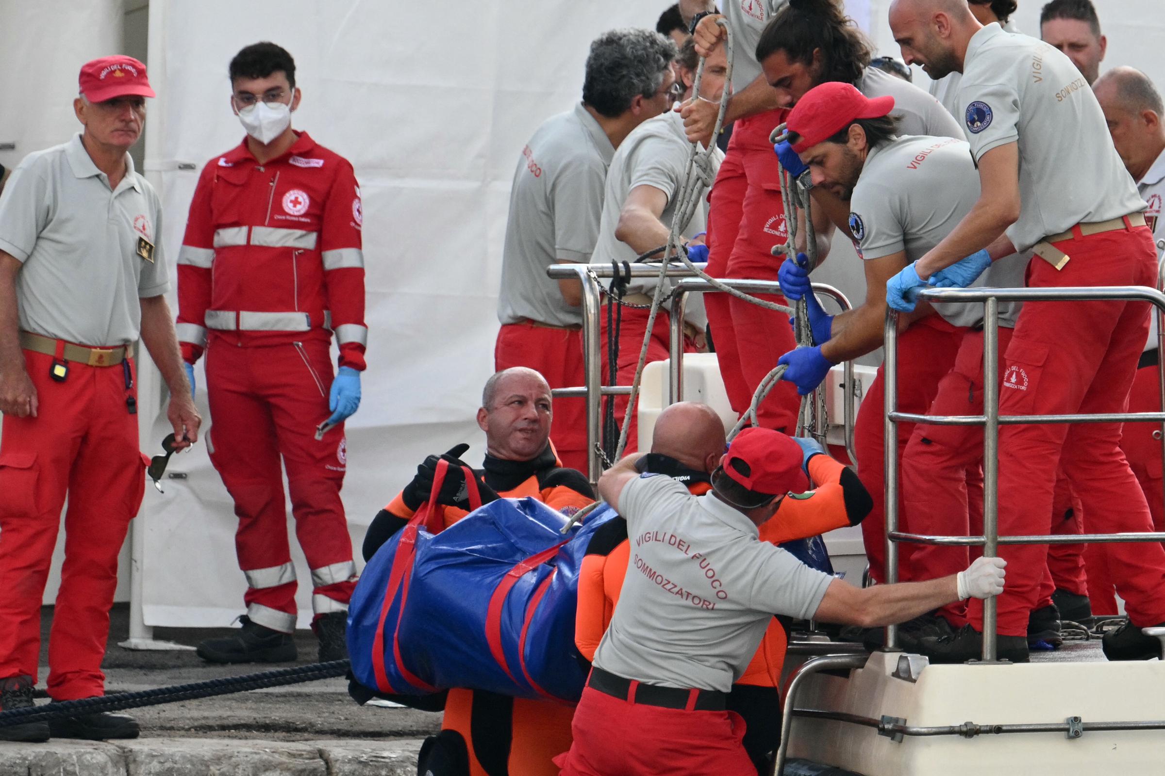 Rescuers carry a body after divers return in Porticello harbor near Palermo, on August 22, 2024, three days after the British-flagged luxury yacht Bayesian sank. | Source: Getty Images