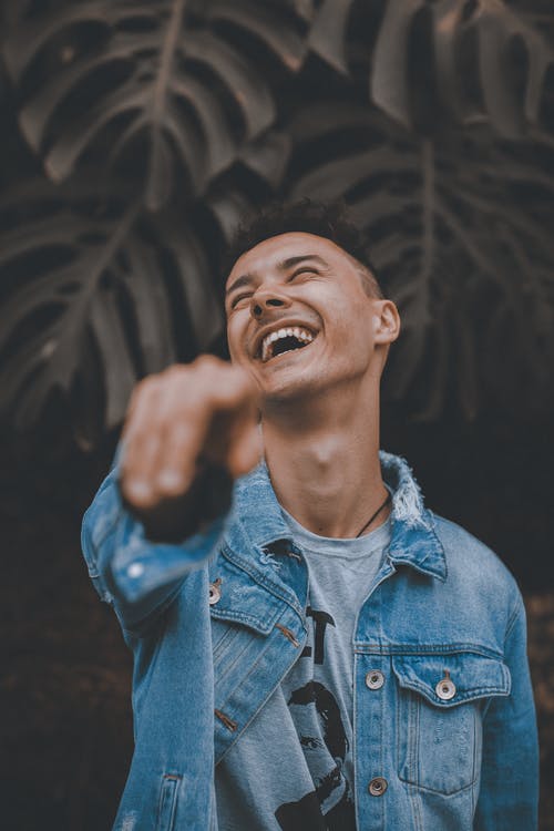 A man laughing out loud and pointing his fingers | Photo: Pexel