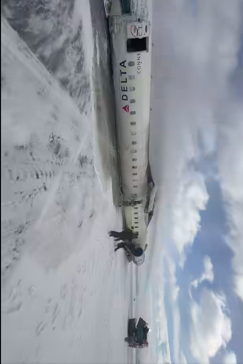 People standing next to the Delta plane that crashed. | Source: Facebook/John Nelson