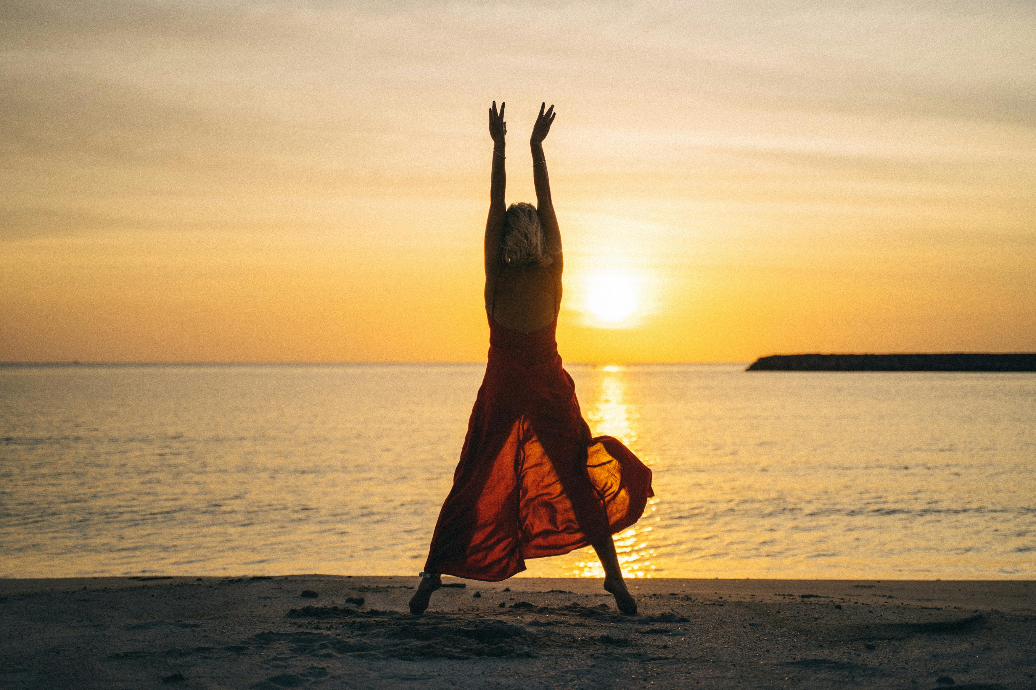 A woman stretching upwards in the sunset | Source: Pexels