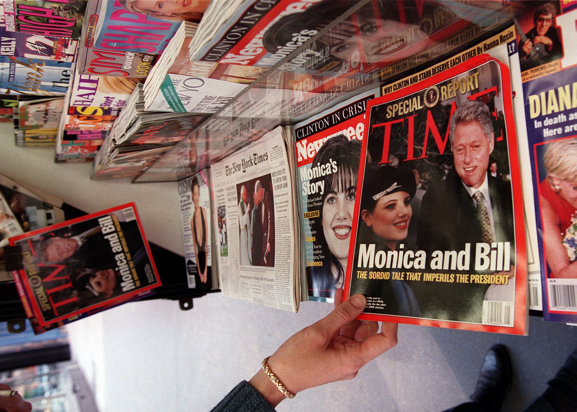 A person reaches for a copy of Time Magazine on a news stand January 26, 1998 in New York. | Source: Getty Images