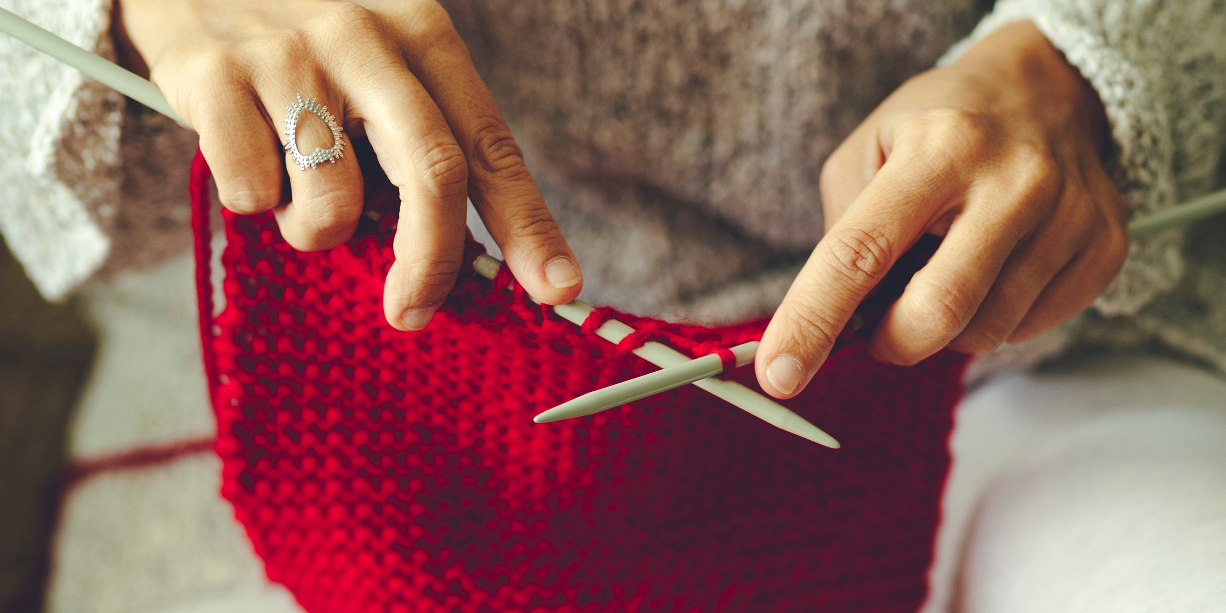 A woman knitting a red sweater | Source: Shutterstock