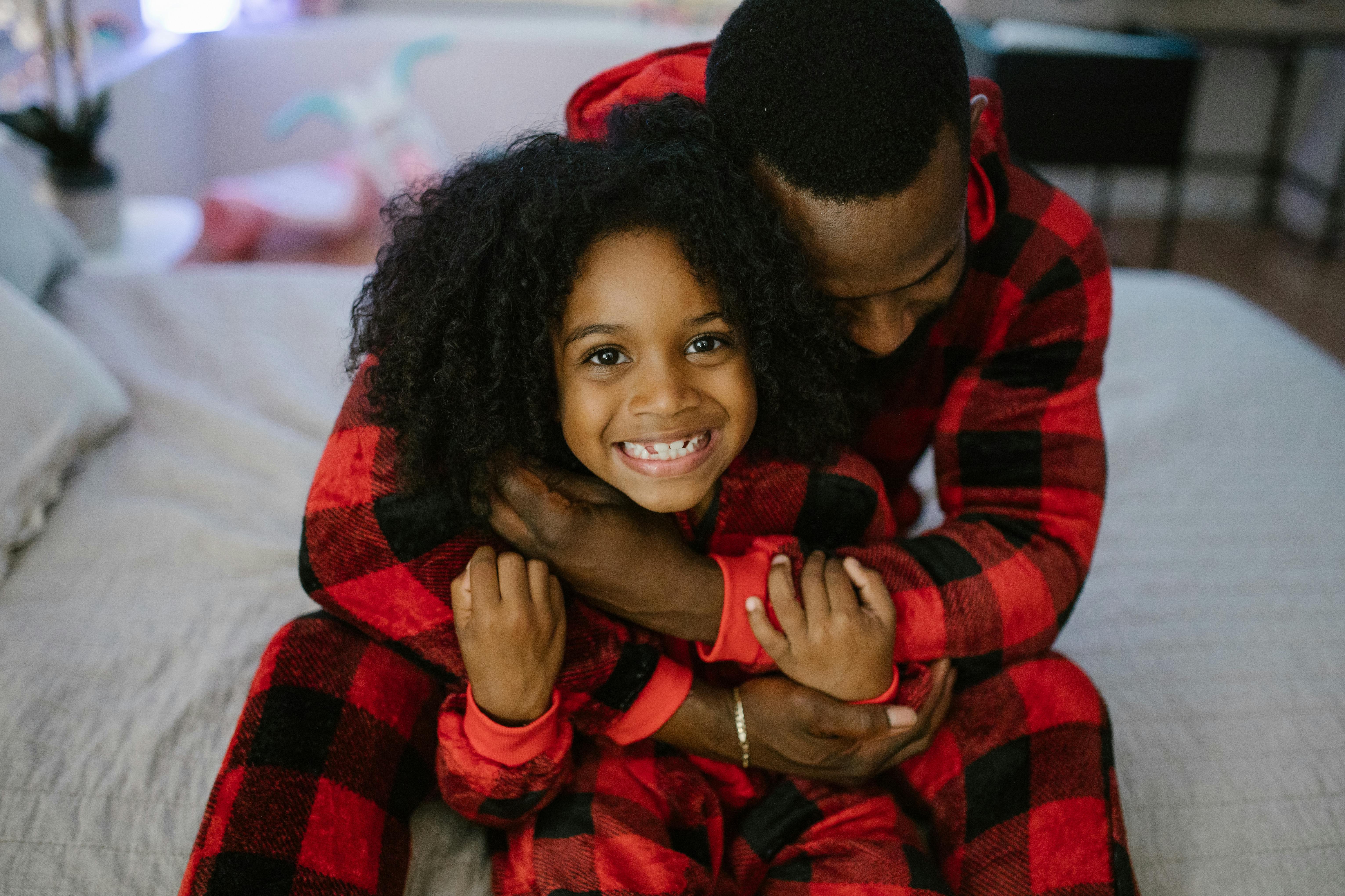 A man hugging his daughter while wearing matching pajamas | Source: Pexels