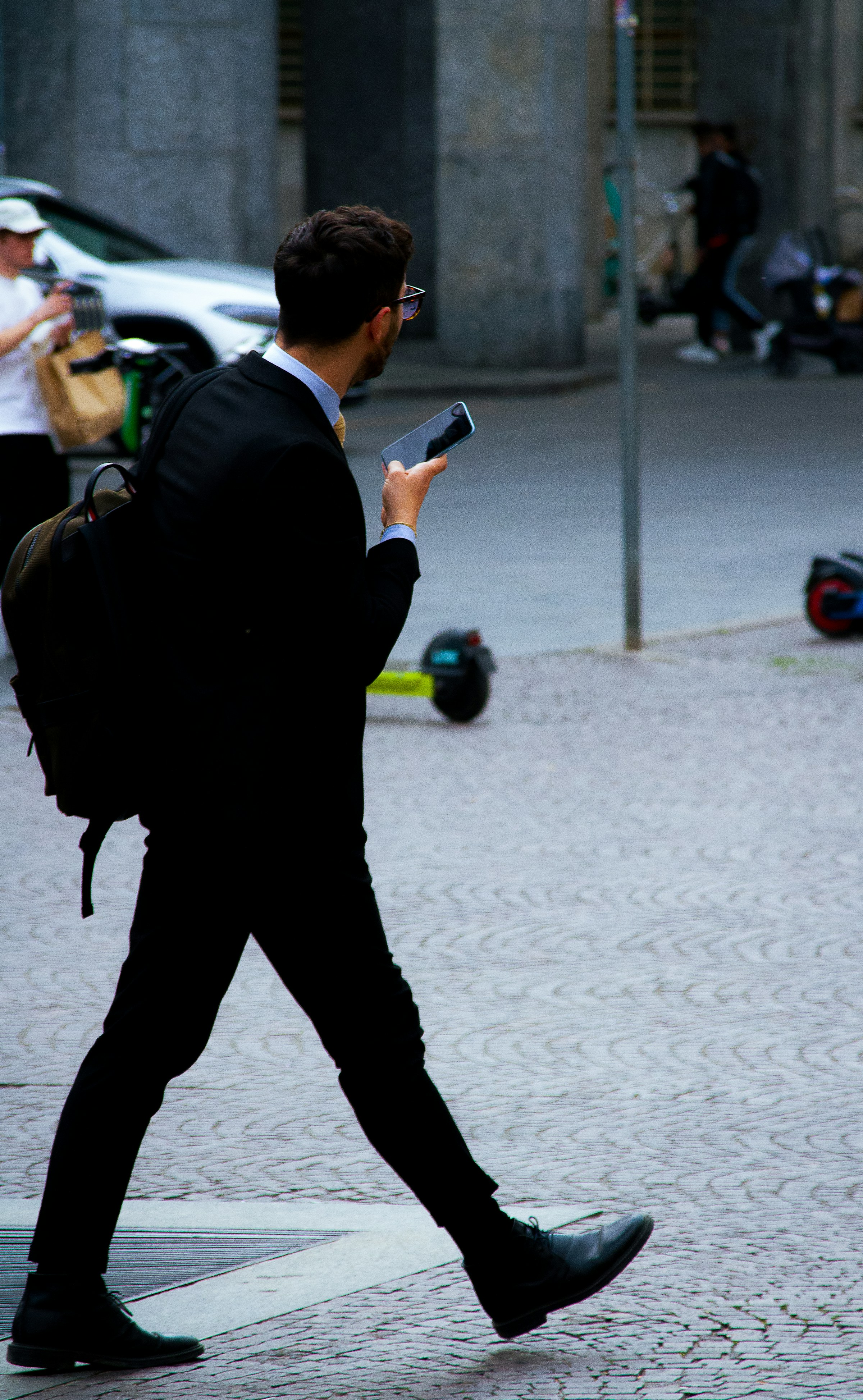 Businessman walking down the street with his phone in his hand | Source: Unsplash