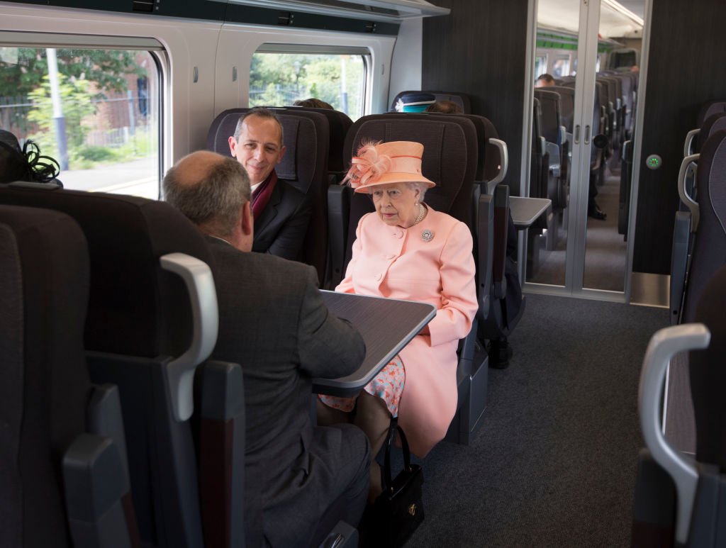 Queen Elizabeth II sits next to Isambard Thomas as she travels by train between Slough train station to Paddington Station on June 13, 2017, in London | Source: Getty Images