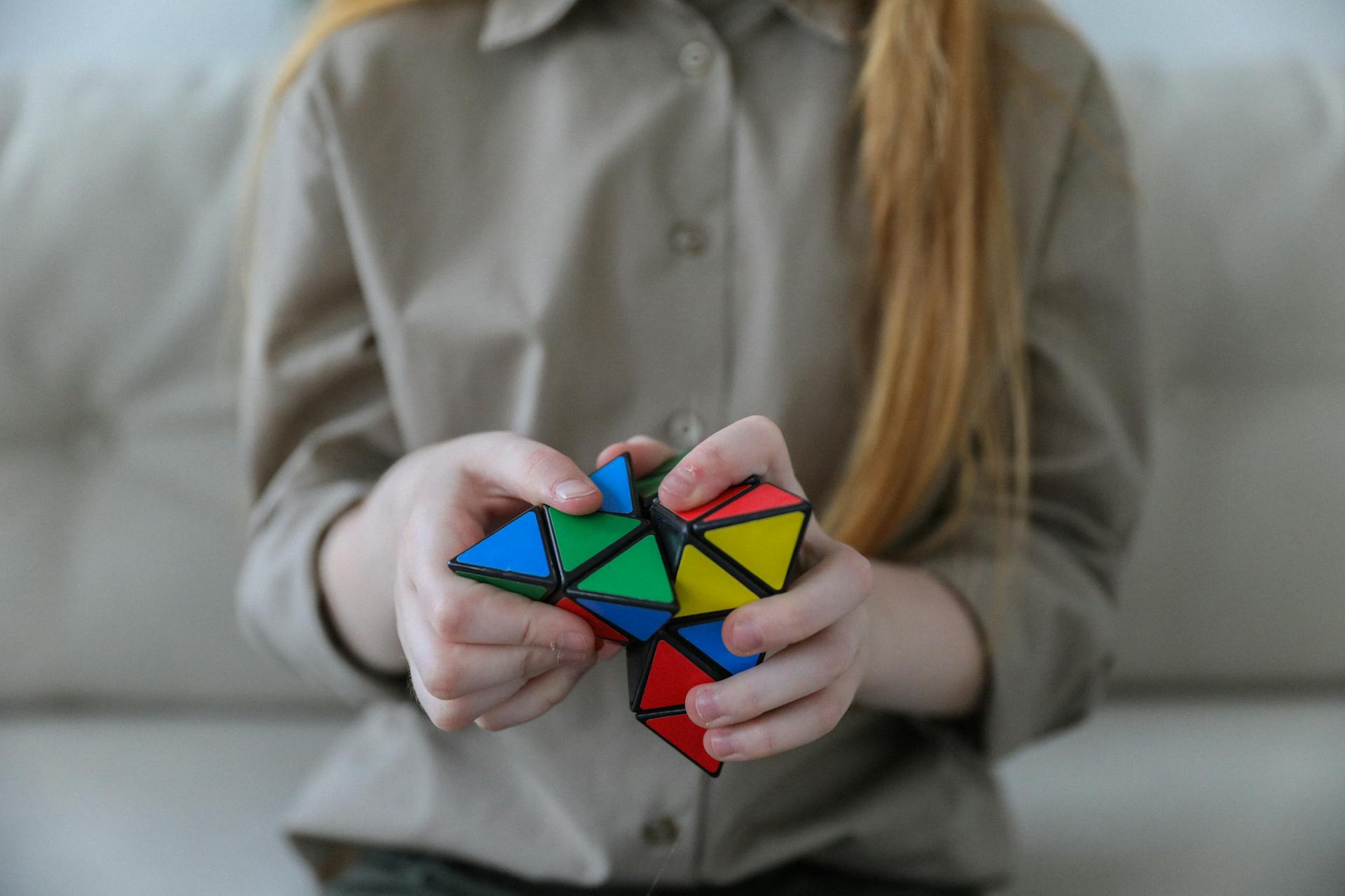 A girl solving a Pyraminx | Source: Pexels