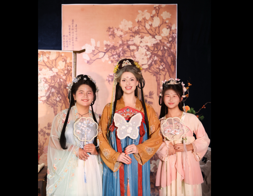 Amanda "Mandy" Karolkiewicz poses with her two adopted daughters while wearing traditional Hanfu clothing during their trip to China, an experience she later described as one of the "coolest" moments of their visit. | Source: TikTok/mandykarolk