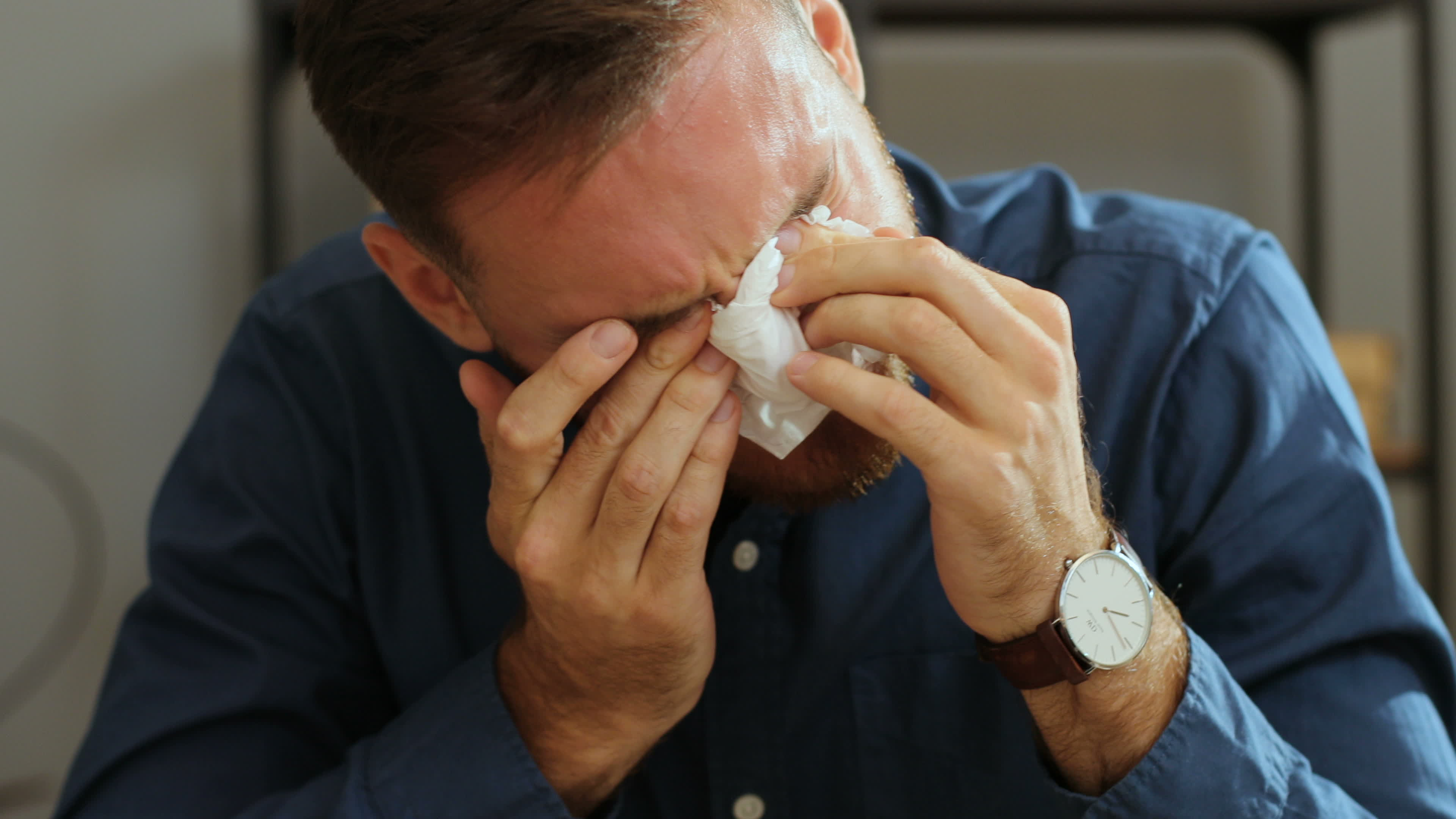 A man wipes his eyes with a napkin while crying | Source: Shutterstock