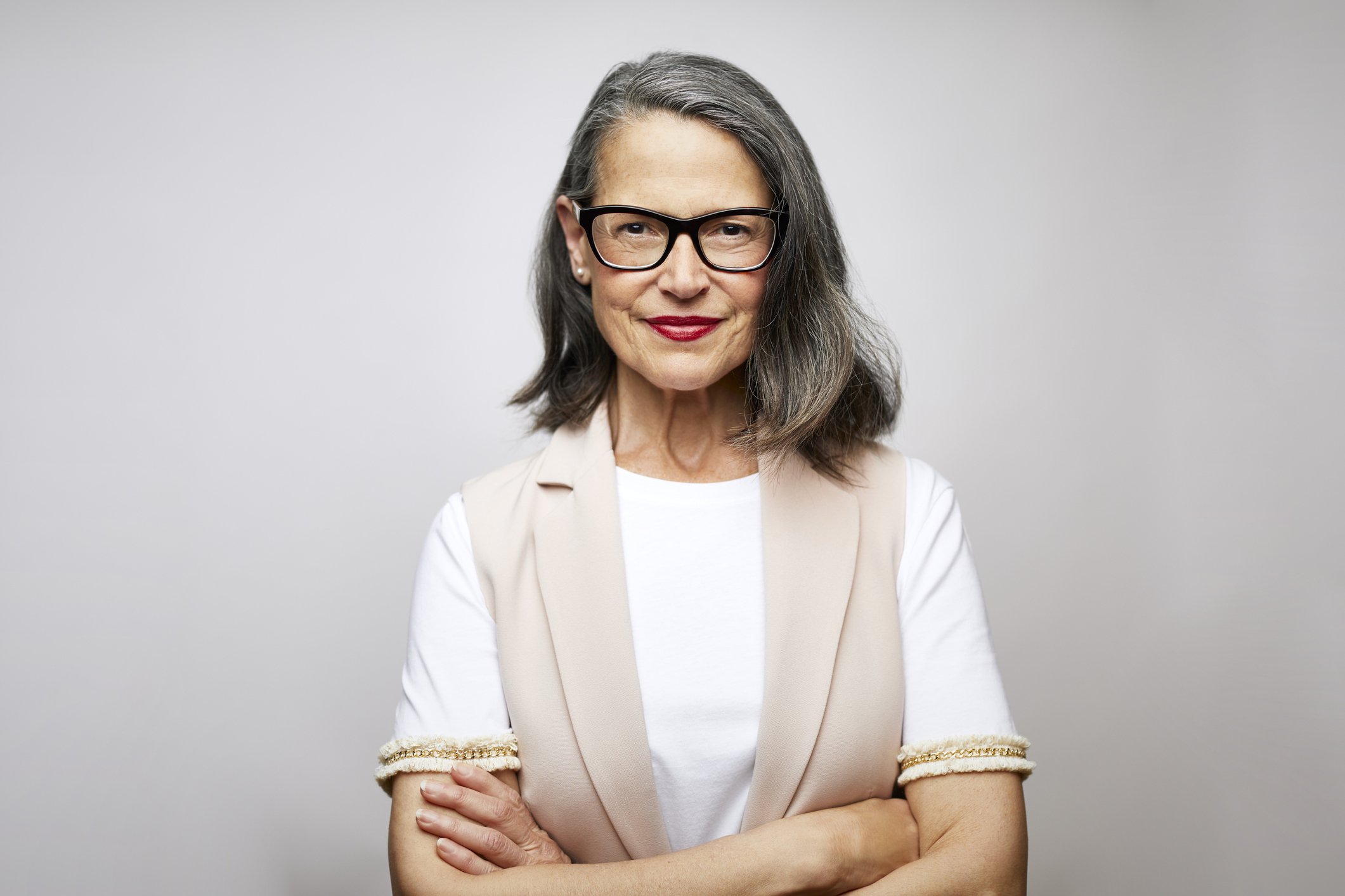 Une femme aux lunettes avec les bras croisés. | Photo : Getty Images