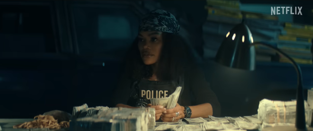 Teyana Taylor as Detective Numa Baptiste counts seized cash in an evidence scene from "The Rip" | Source: YouTube/Netflix