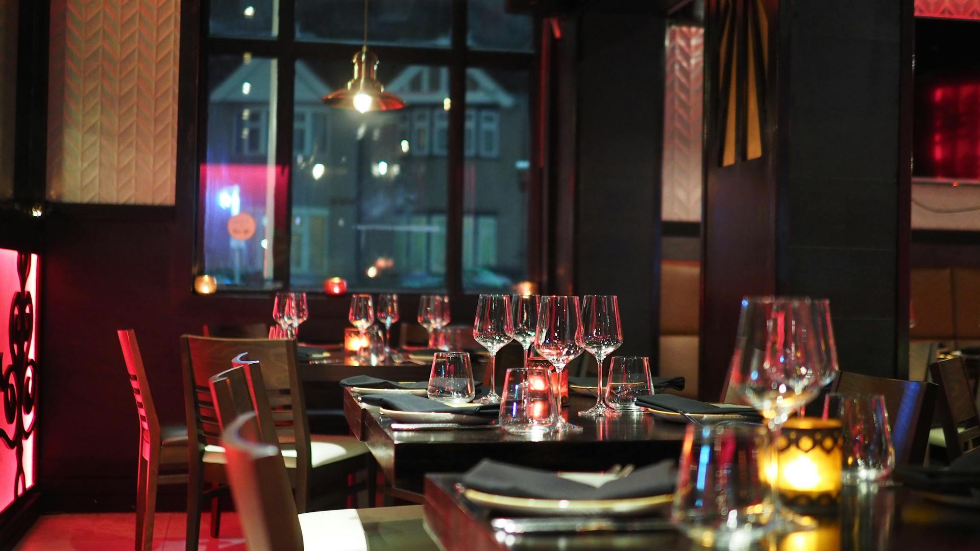 A photo showing wine glasses placed on the tables of a restaurant | Source: Pexels