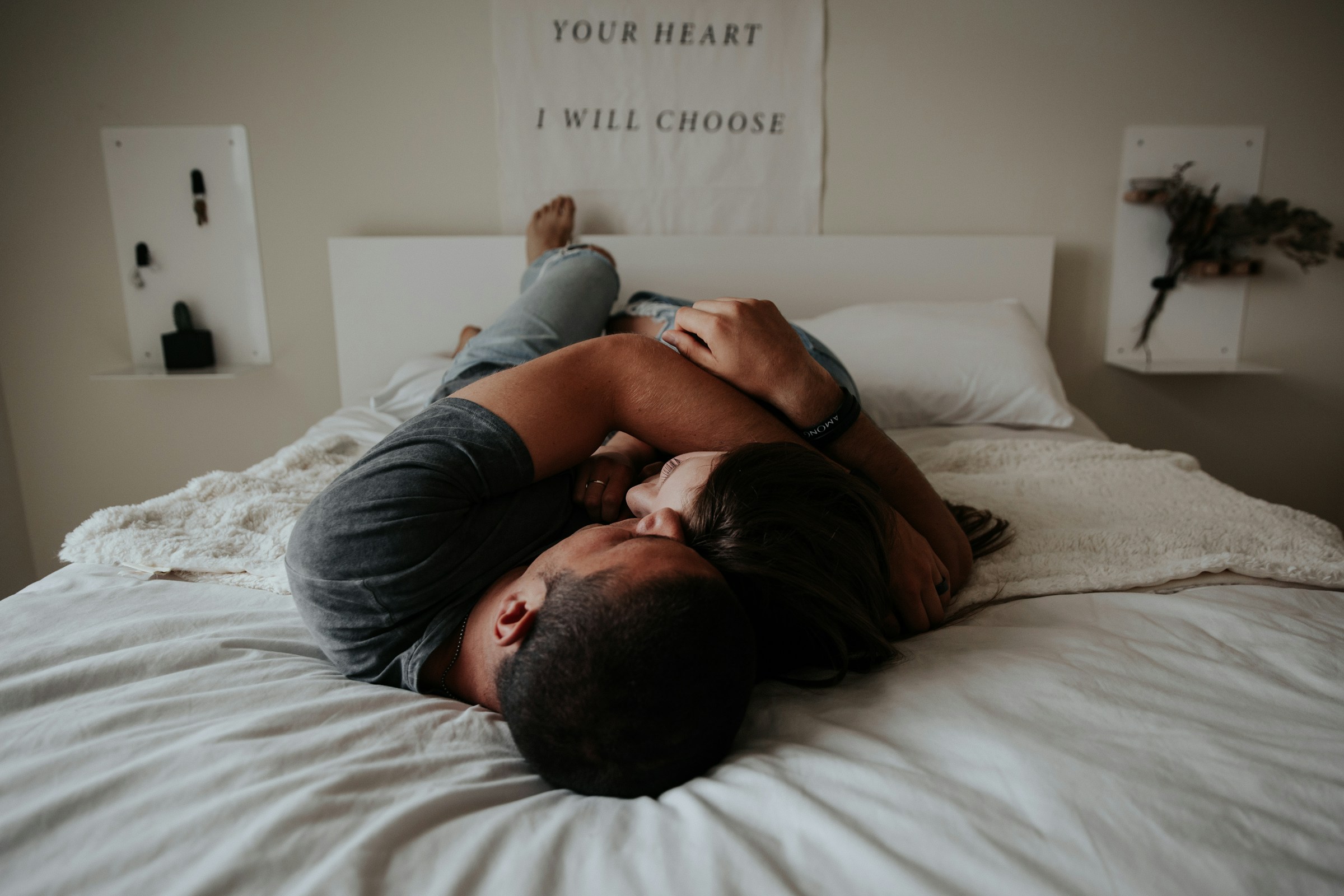 A couple cuddling on a bed | Source: Unsplash