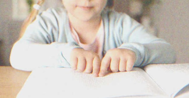 Girl reading in Braille | Source: Shutterstock
