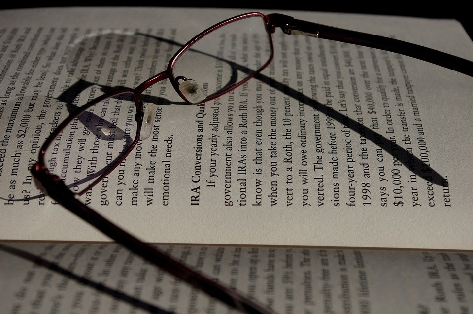 A pair of reading glasses and a book. | Photo: Pixabay