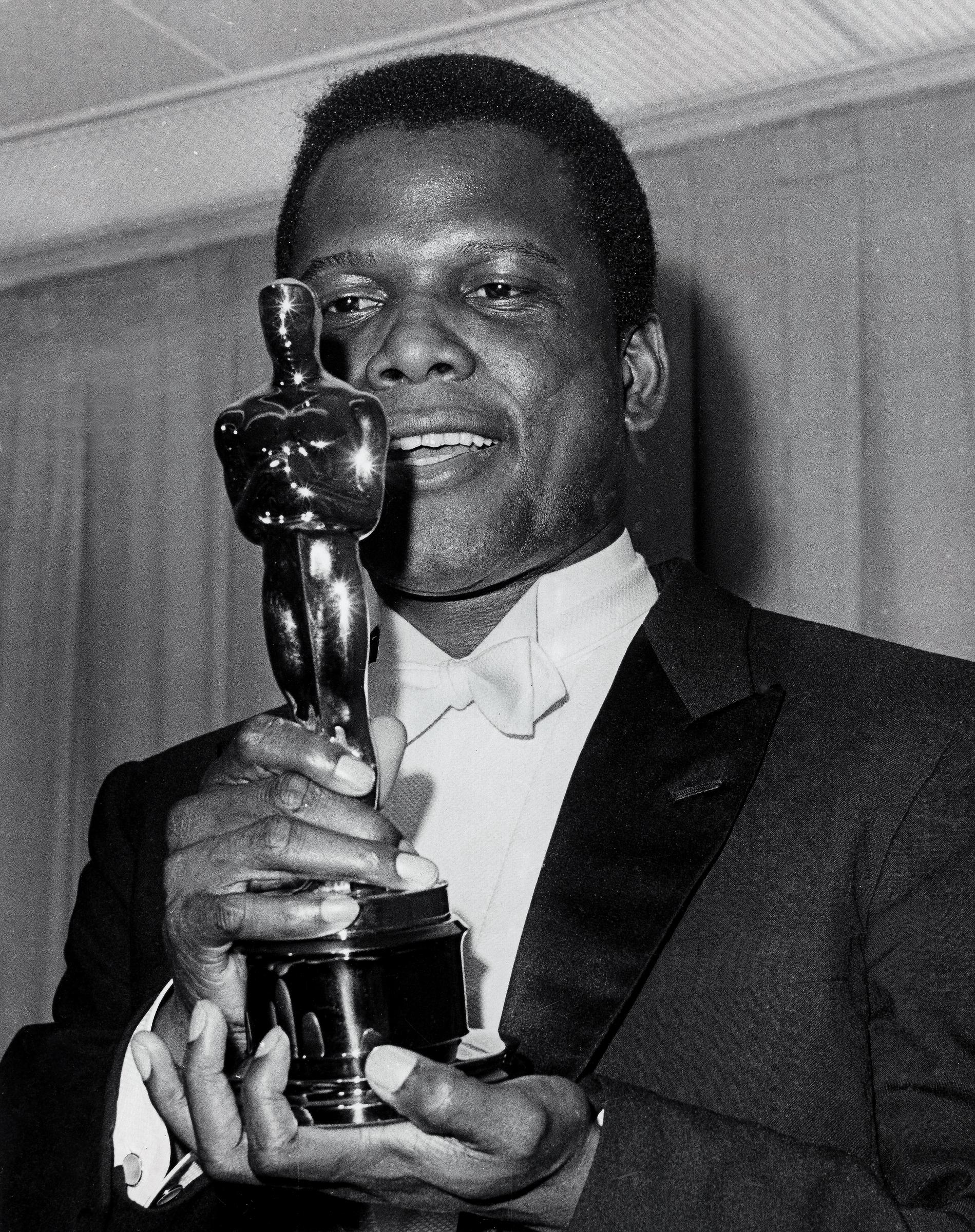 Sidney Poitier pictured holding the Oscar for his role in "Lilies of the Field," on January 1, 1964 | Source: Getty Images