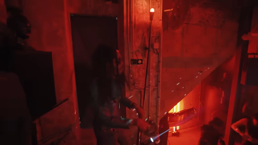 Lenny moves through the red-hued speakeasy, showing off the cozy, underground club vibe. | Source: YouTube/@Archdigest