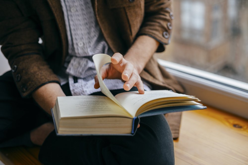 Joven sentado leyendo un libro. | Foto: Shutterstock