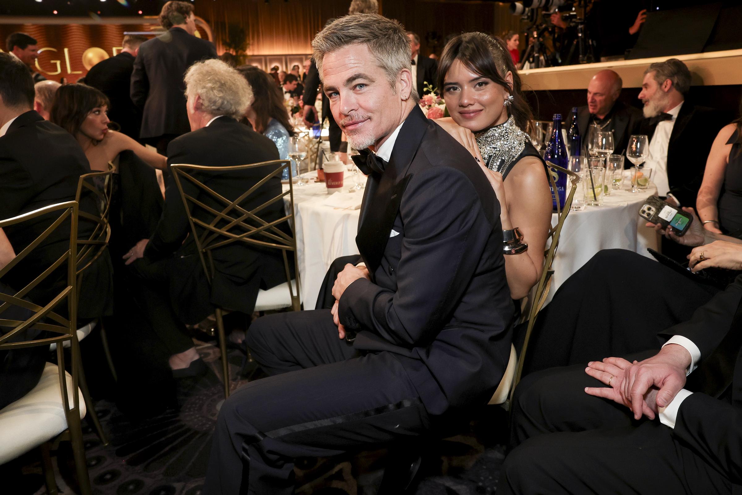 Chris Pine and Keana Sky Wenger are seated close together, flashing relaxed smiles as they take in the awards night excitement from their table.