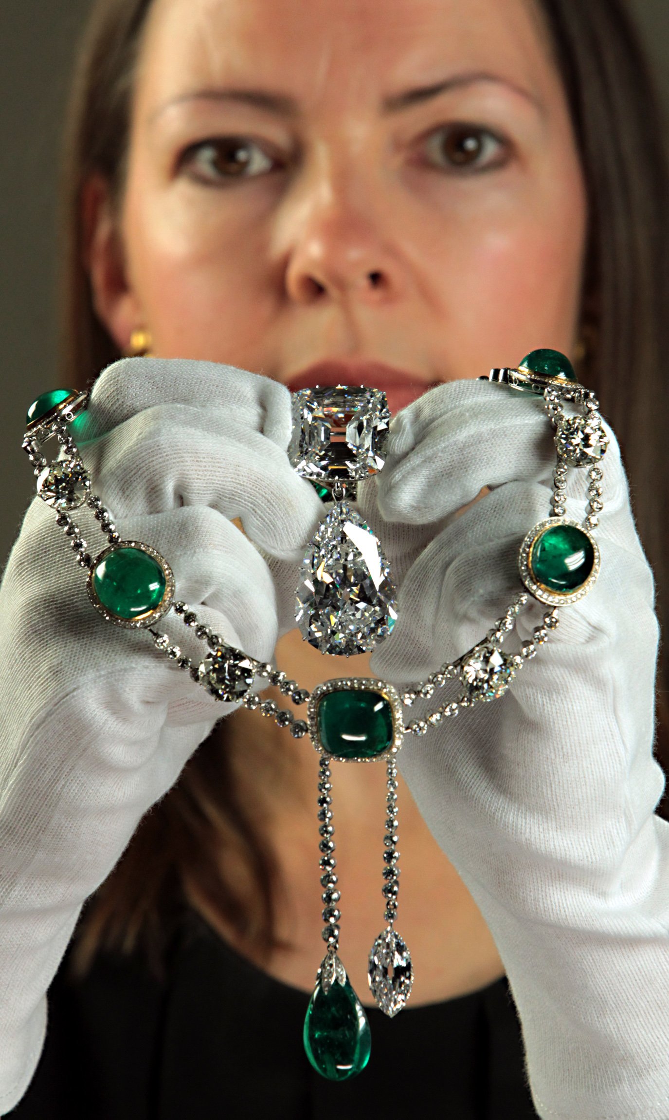 Exhibition curator Caroline de Guitaut holds the Cullinan Brooch and Cullinan V necklace pendant at the Queens Gallery in Buckingham Palace, central London, part of an exhibition of royal gems staged to mark the Queens 60-year reign. | Source: Getty Images