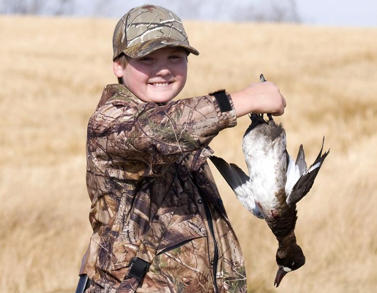 A young man holding a duck | Photo: Shutterstock