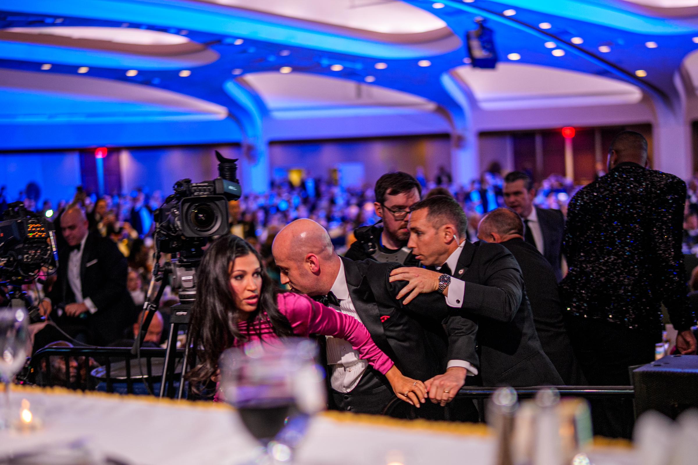 Stephen Miller and Katie Miller are taken out of the ballroom by security agents during an incident at the White House Correspondents Association dinner at the Washington Hilton on April 25, 2026, in Washington, DC | Source: Getty Images