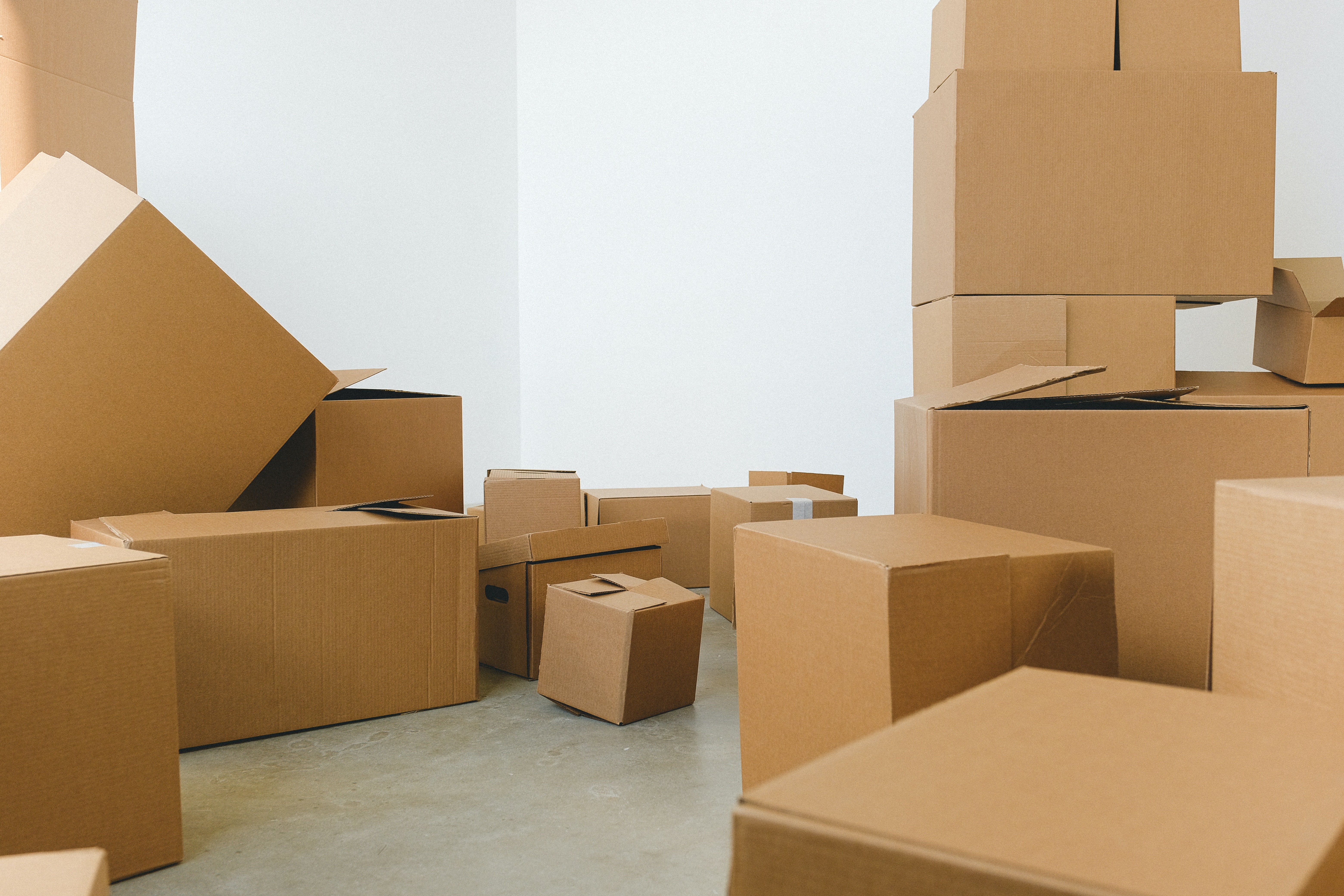 Pile of cardboard boxes scattered on floor. | Source: Pexels