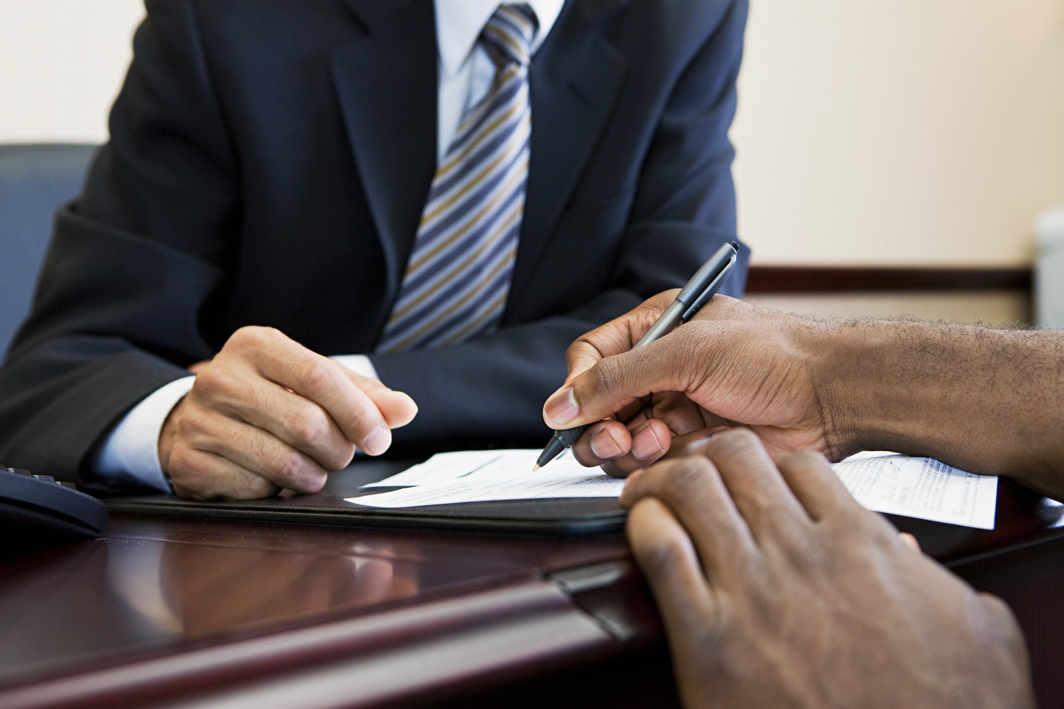 Customer signing paperwork with bank manager | Photo: Getty Images