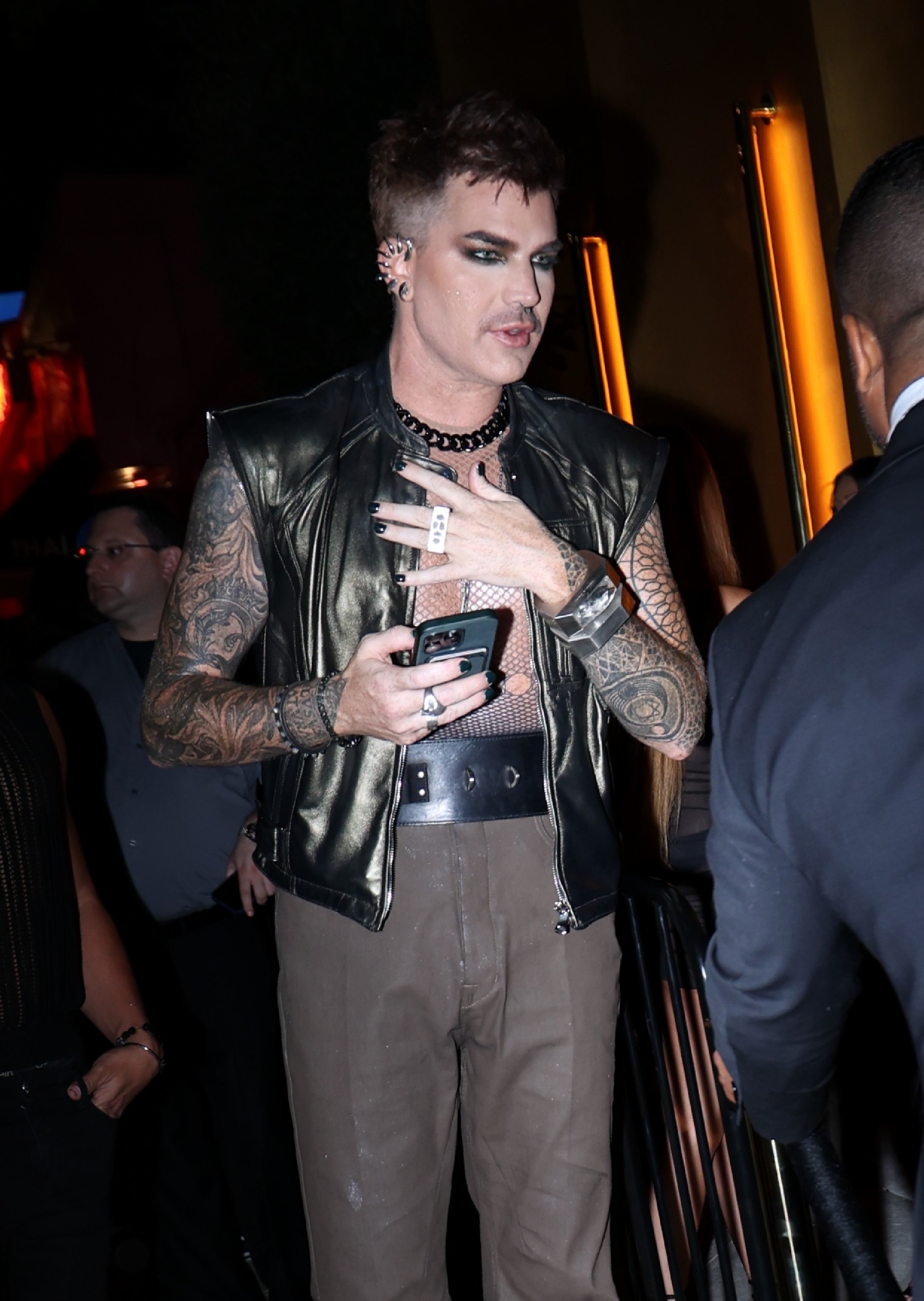 Spotted on August 1, 2024, arriving at the grand opening of "KEYS" in West Hollywood, Adam Lambert makes a bold entrance in a sleeveless leather vest, mesh top, and statement jewelry —fully embracing his edgy, alternative glam rock aesthetic.