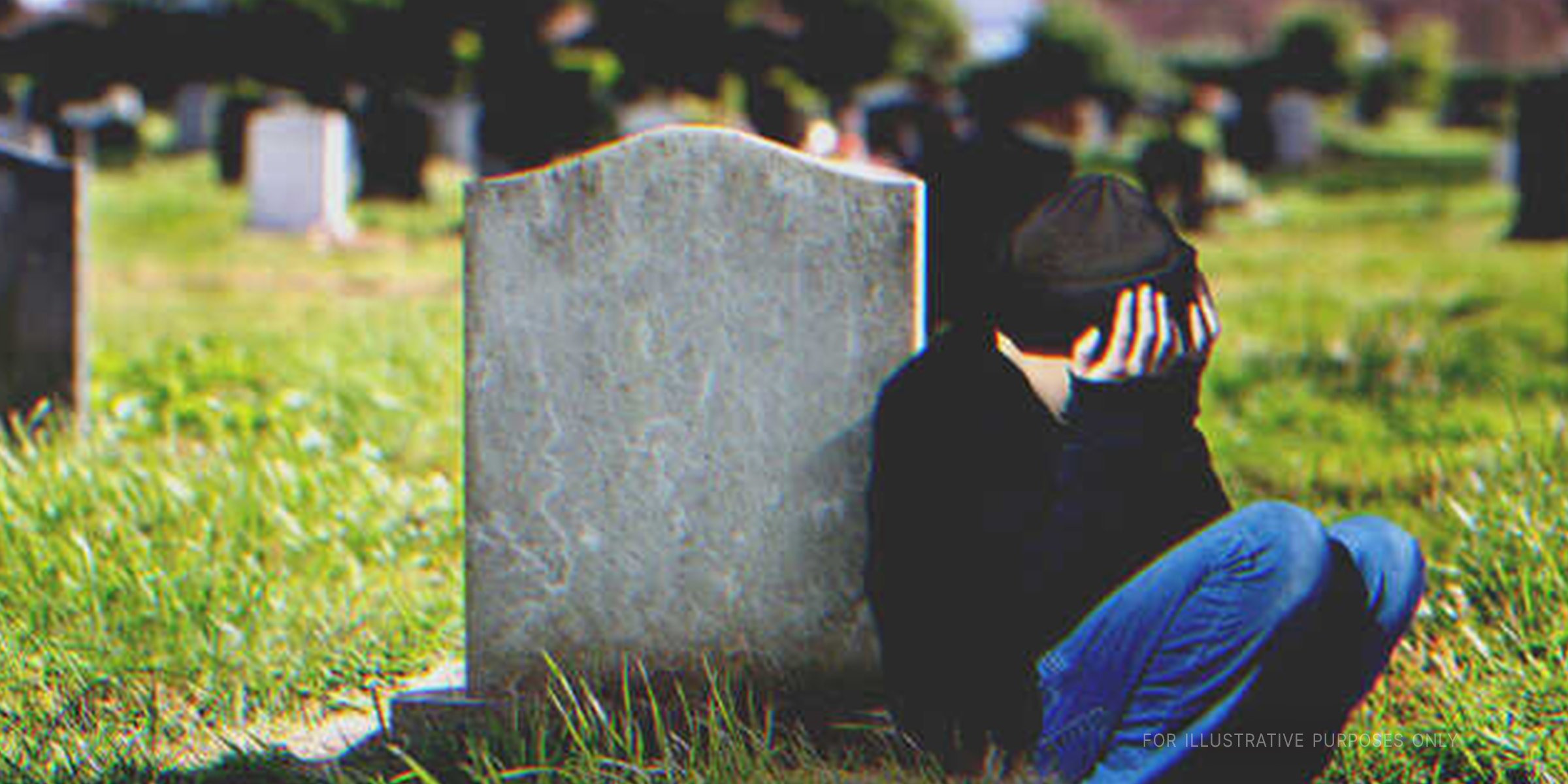 Young boy crying next to tombstone | Shutterstock