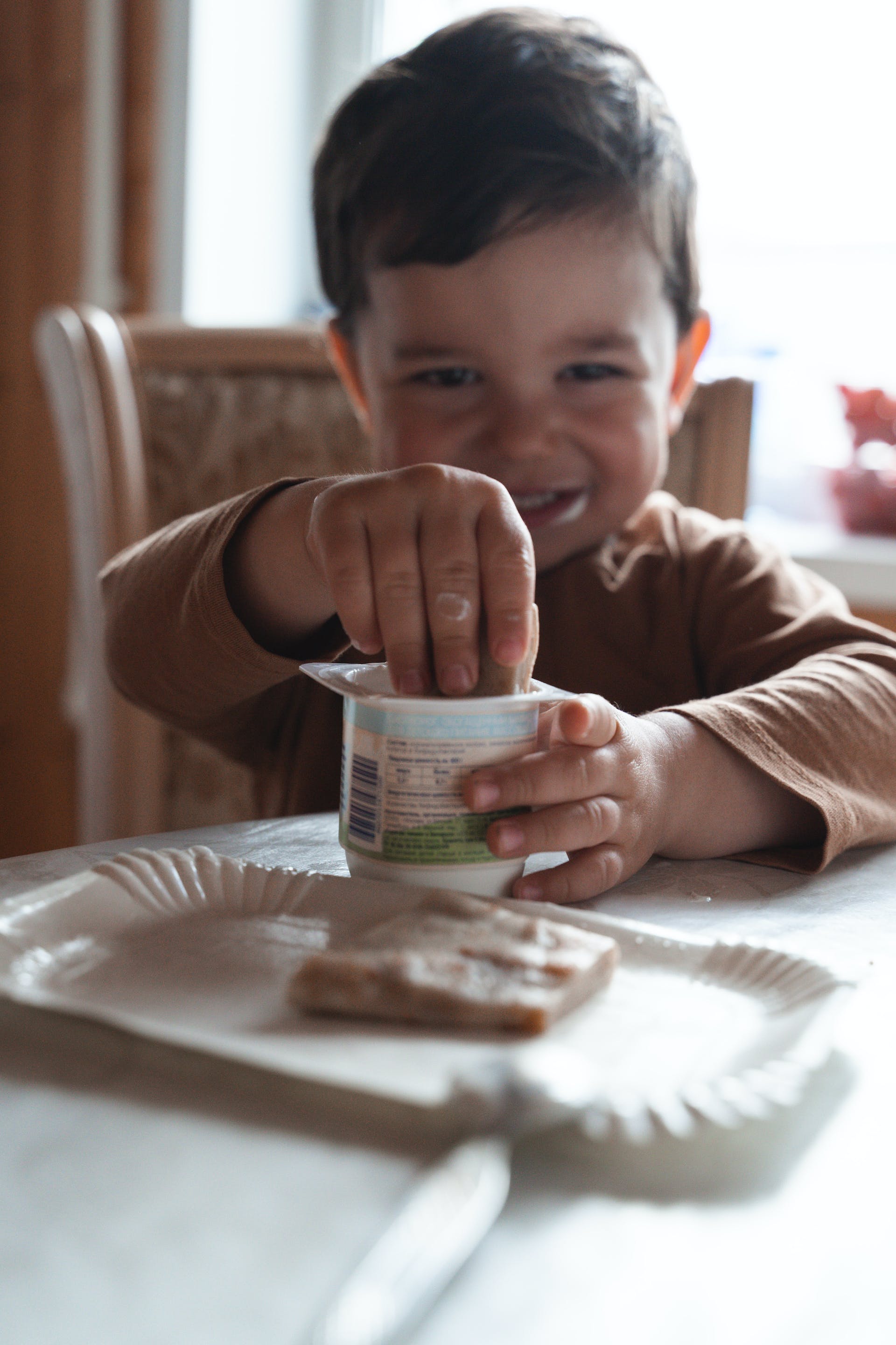 Little boy eating yogurt | Source: Pexels