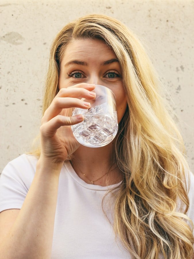 Une femme buvant de l'eau. l Source : Unsplash