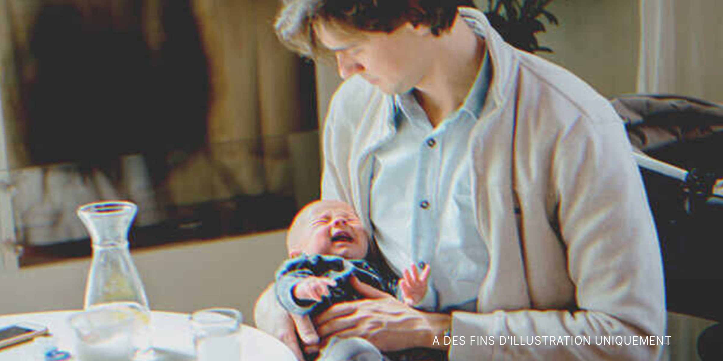 Homme avec bébé qui pleure dans ses bras | Source : Shutterstock