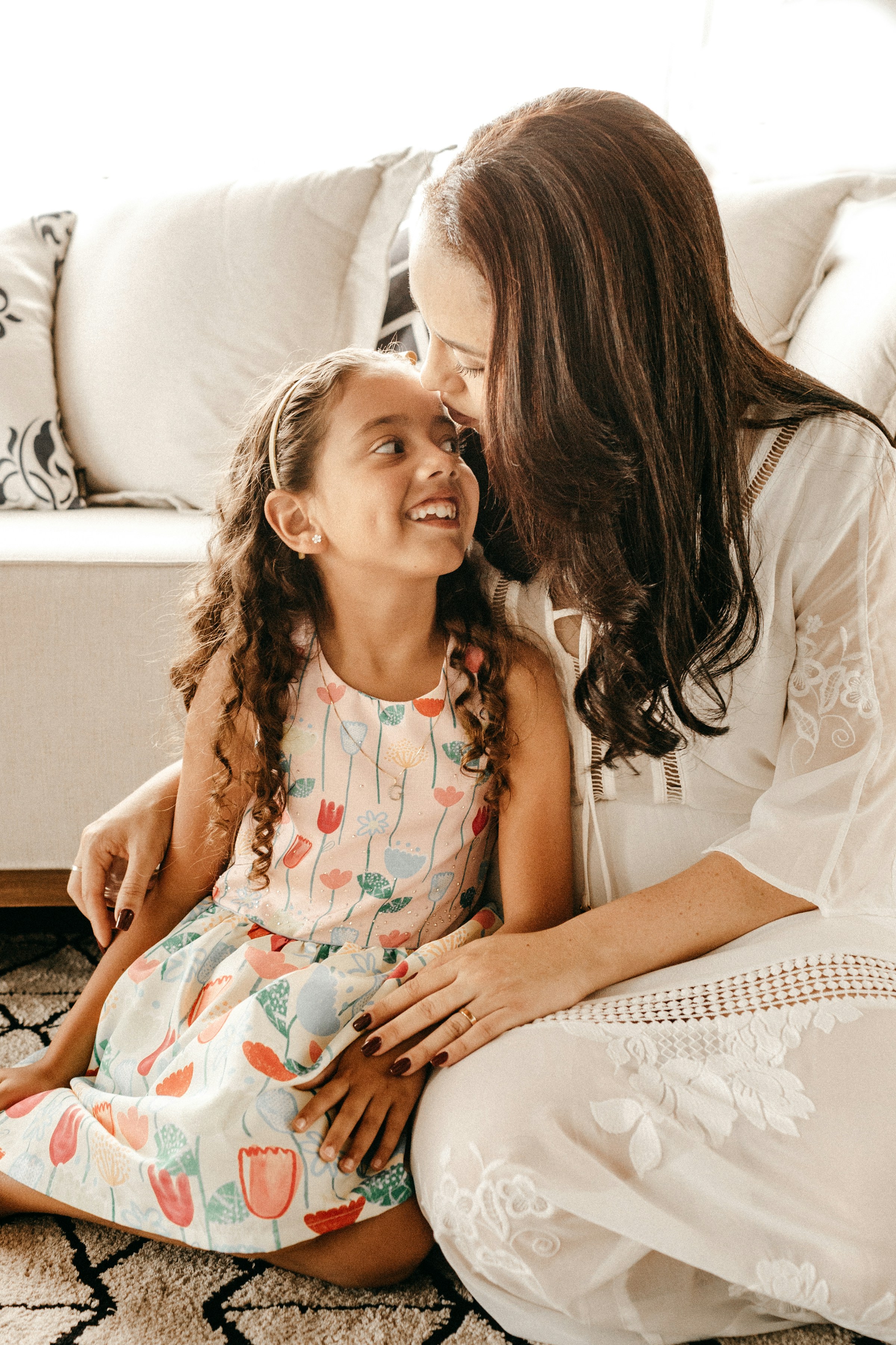 A mother sitting on the floor with her little girl | Source: Unsplash