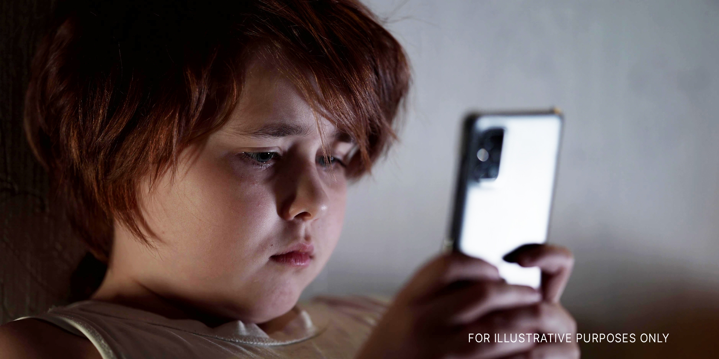 Ein Kind schaut auf ein Mobiltelefon│Quelle: Shutterstock