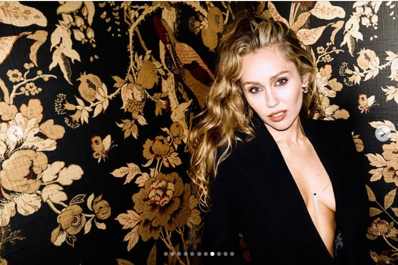 Miley Cyrus poses confidently against an ornate floral backdrop, as seen from her post dated October 25, 2025 | Source: Instagram/mileycyrus