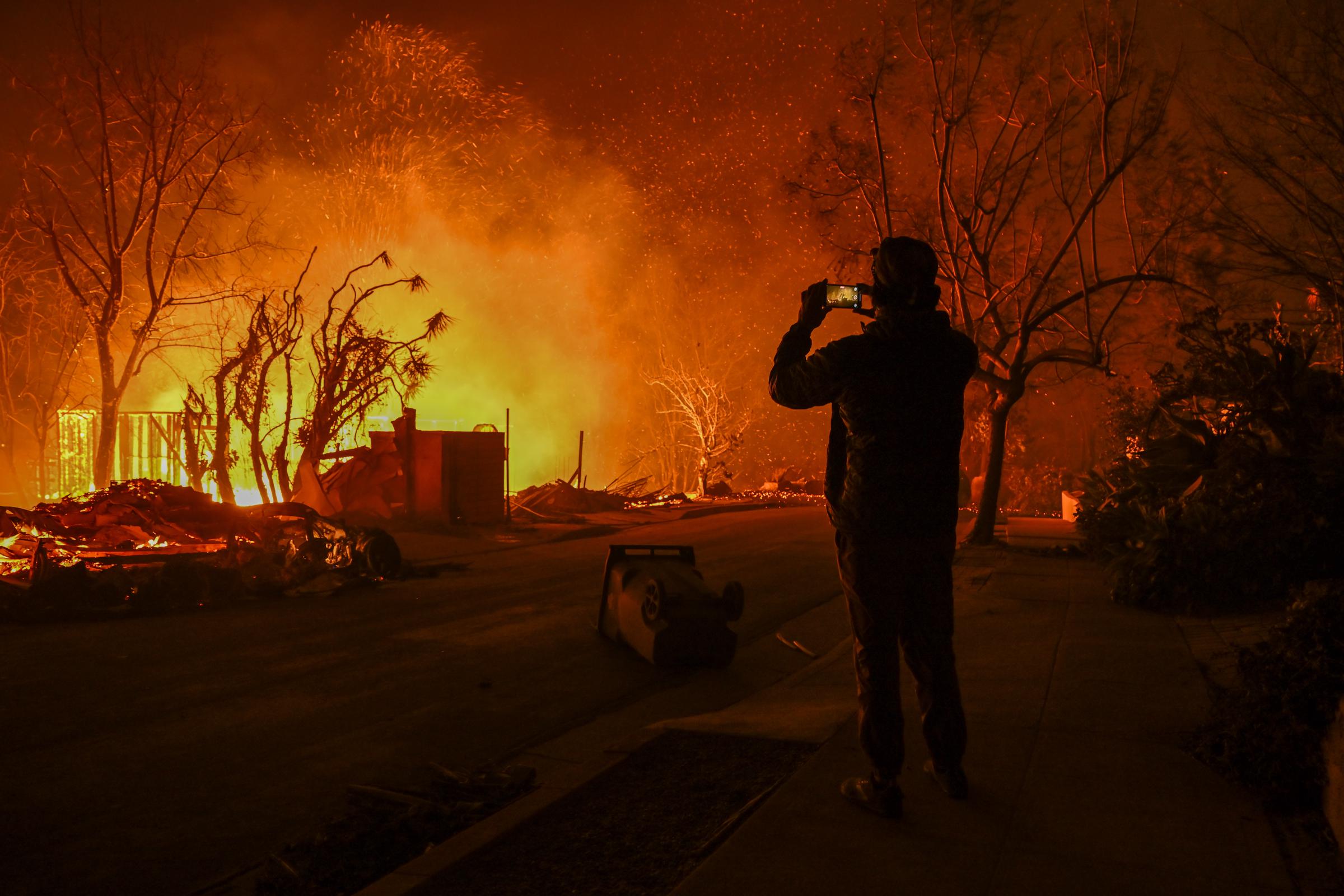 A civilian recording a wildfire's destruction in Pacific Palisades, California on January 8, 2025. | Source: Getty Images