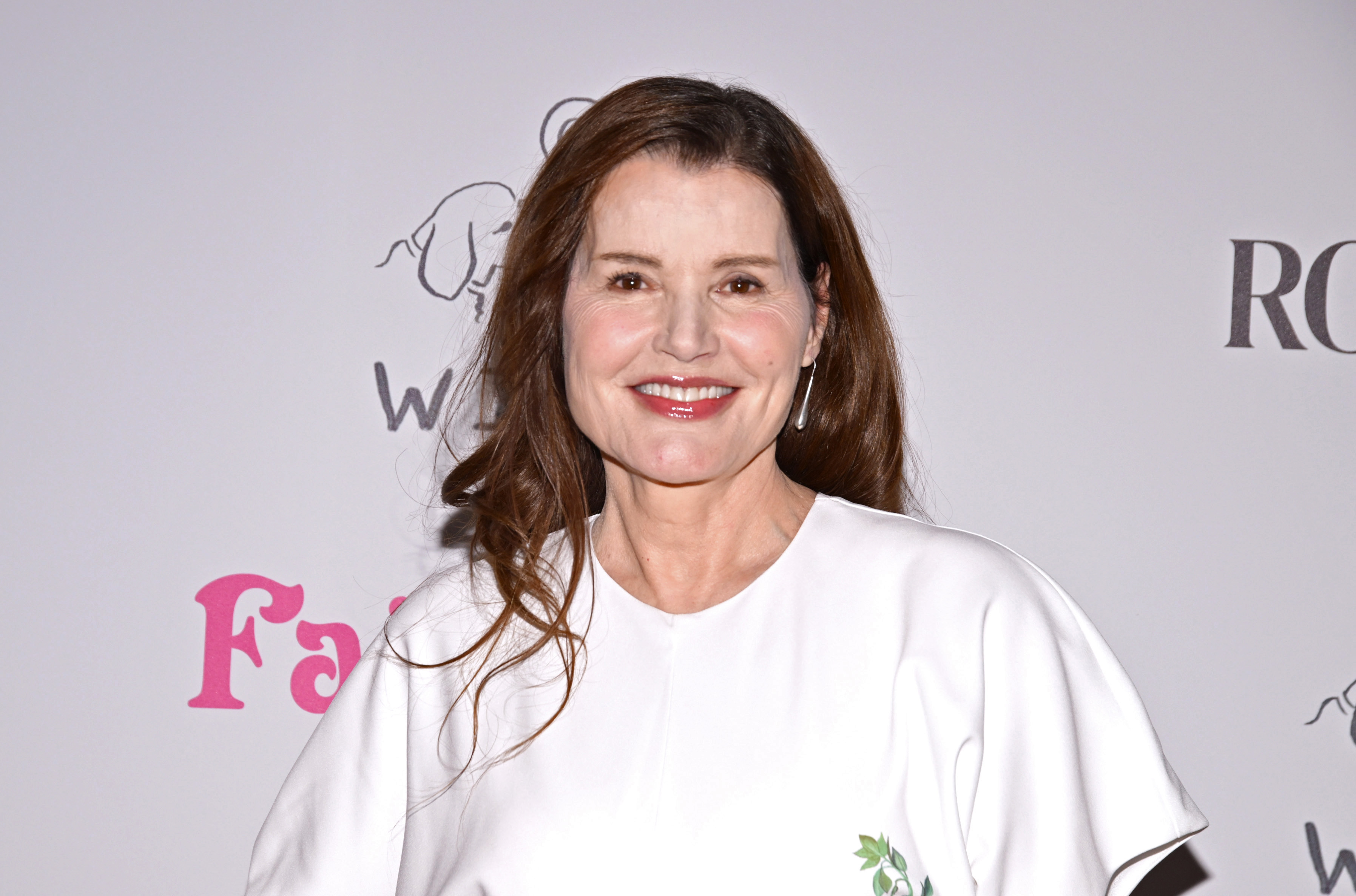 Geena Davis embraced minimalist elegance in a crisp white dress with flowing sleeves while attending the "Fairyland" premiere. Her natural makeup, loose brunette hair, and subtle accessories kept the spotlight on her timeless beauty.