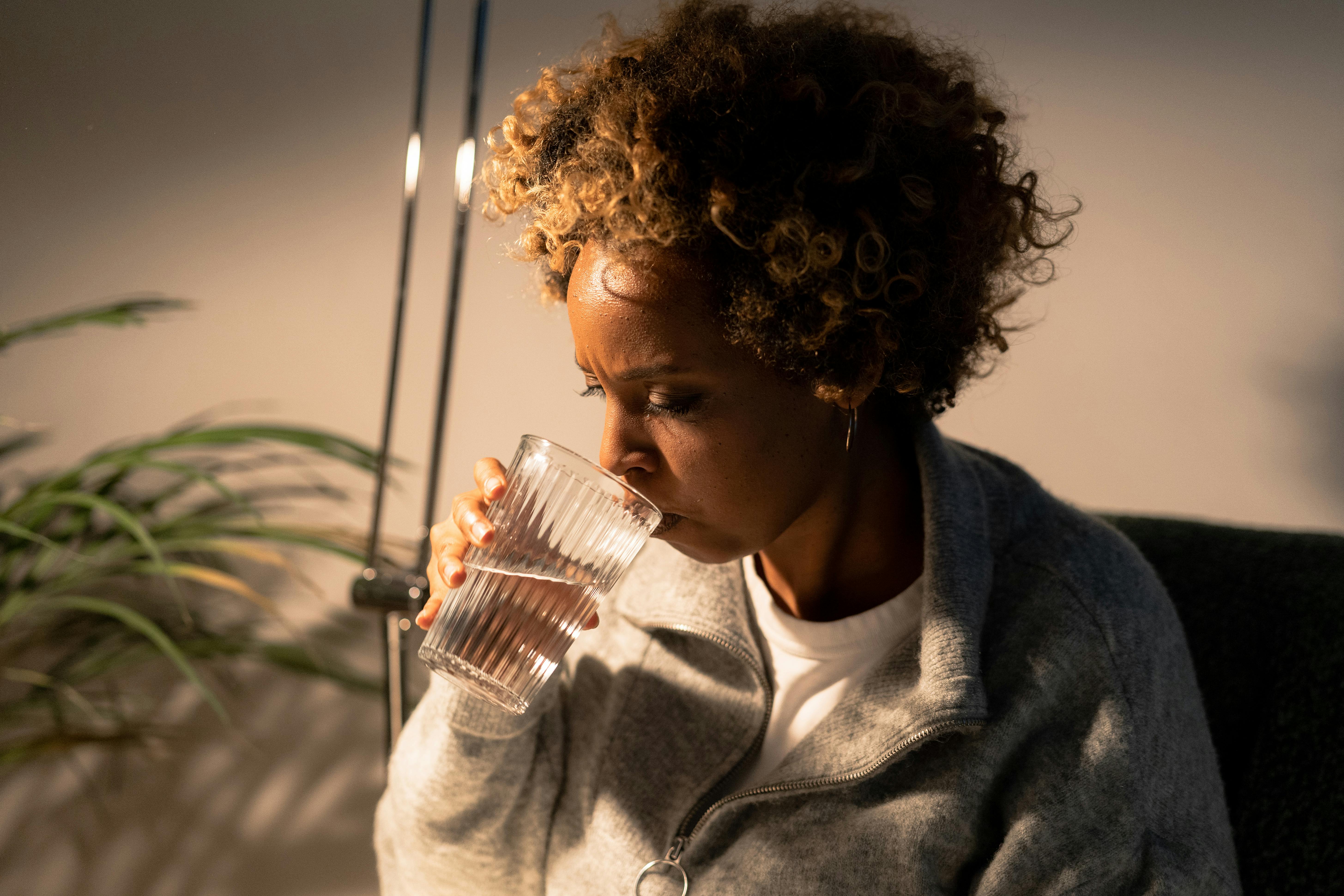 A woman drinking water. | Source: Pexels