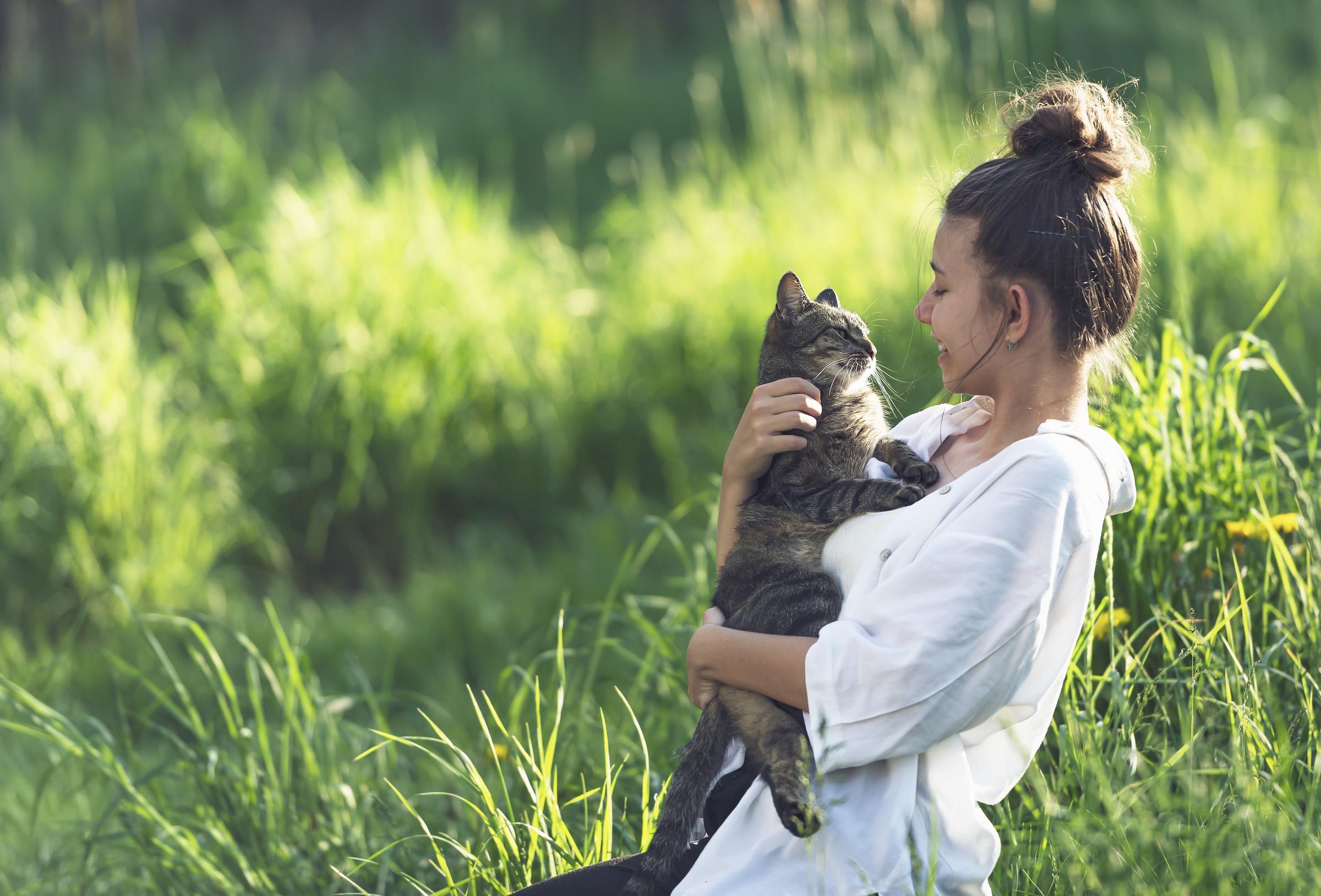 A girl holding a black cat | Source: Pexels